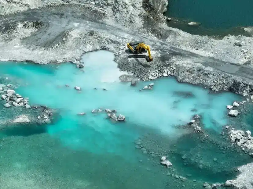 escavação perto de lago com máquina