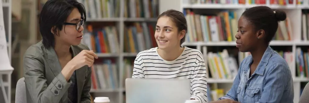 estudantes em biblioteca conversando