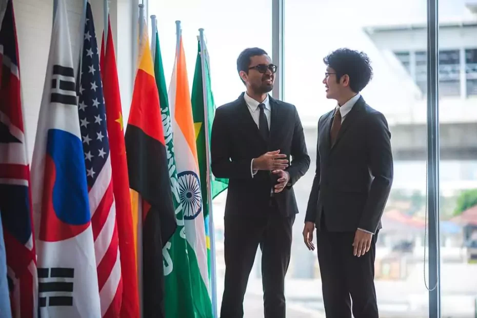 dois homens ao lado de bandeiras de vários países