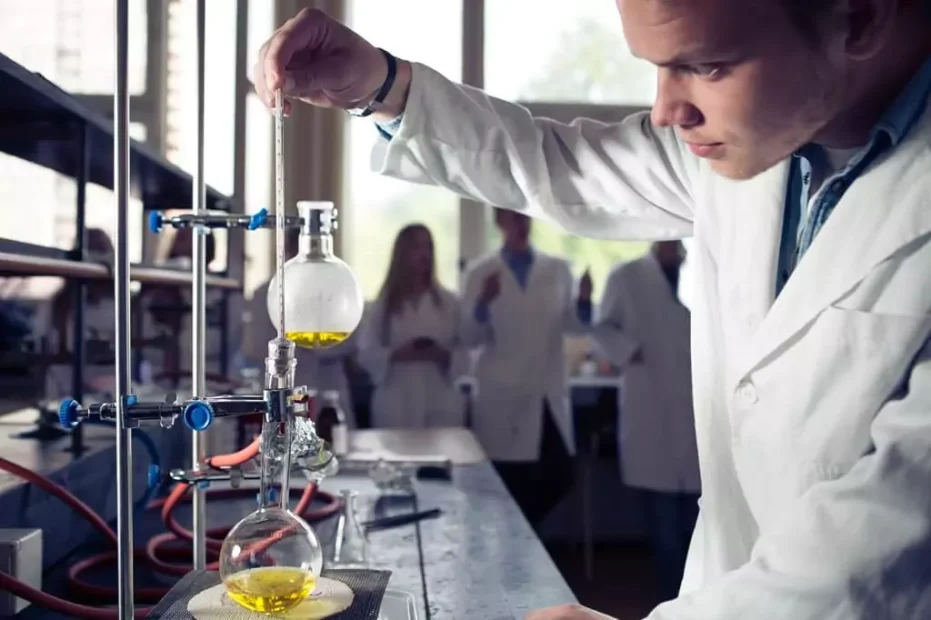 rapaz fazendo experimento de química em laboratório com colegas