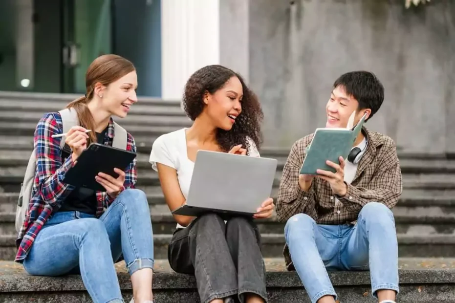 estudantes sentados em escada de faculdade