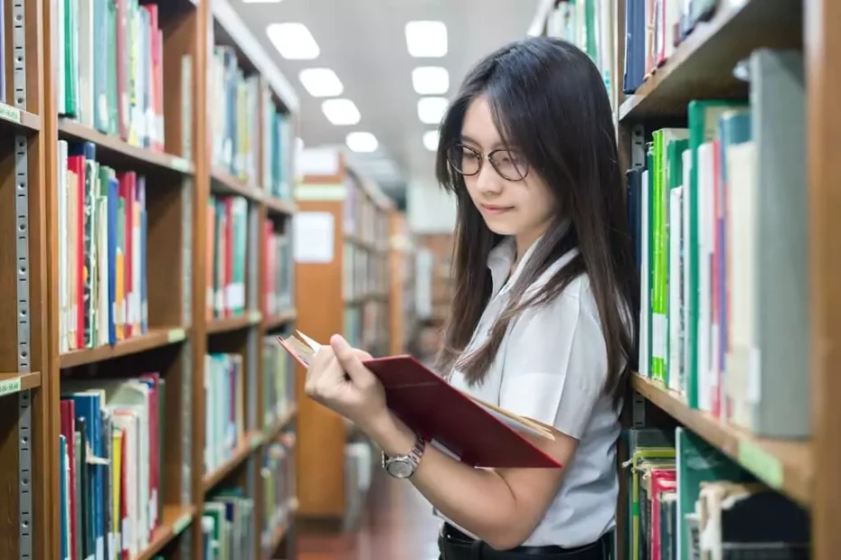 garota lendo livro em biblioteca