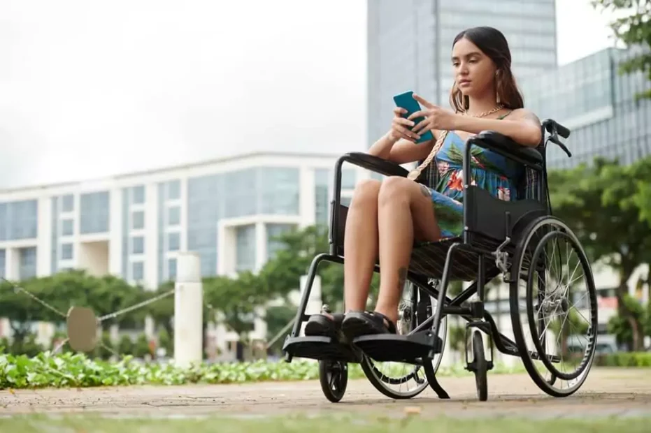 moça em cadeira de rodas mexendo em celular