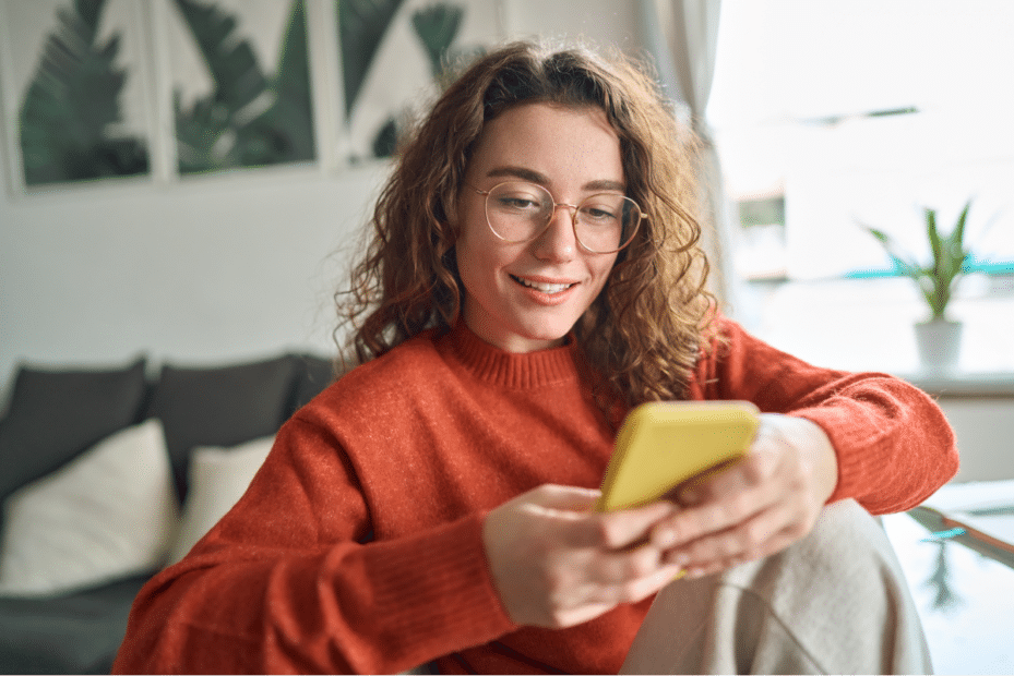 Mulher jovem olhando para algo no celular. Segunda fase Unicamp.