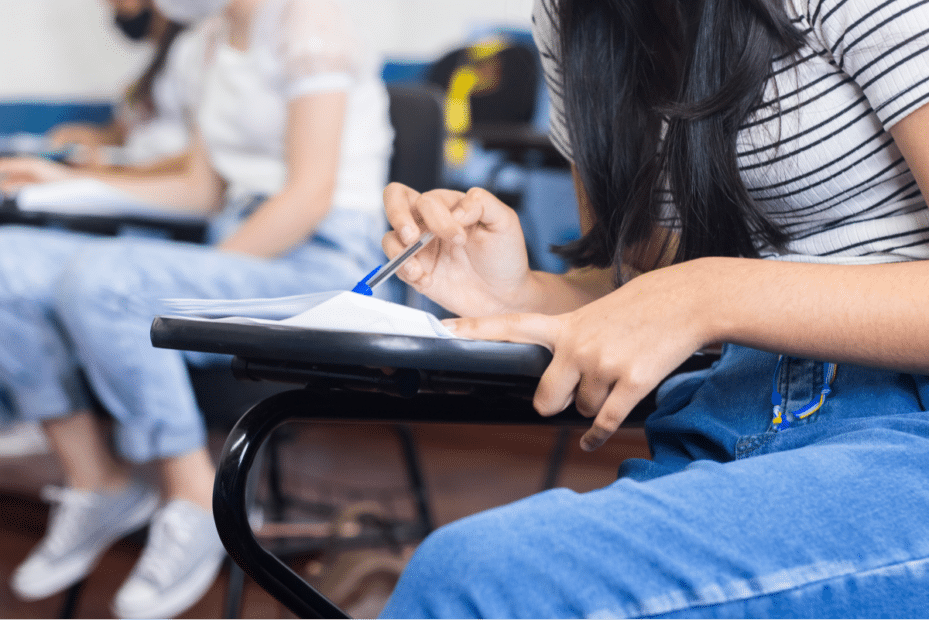 Imagem aproximada de uma mulher fazendo uma prova em uma sala de aula. Segunda fase Unicamp.