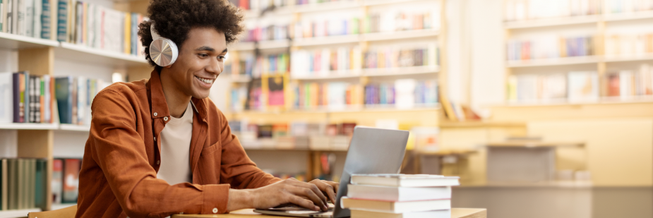 Homem jovem estudando usando um computador na biblioteca. Segunda fase Unicamp.