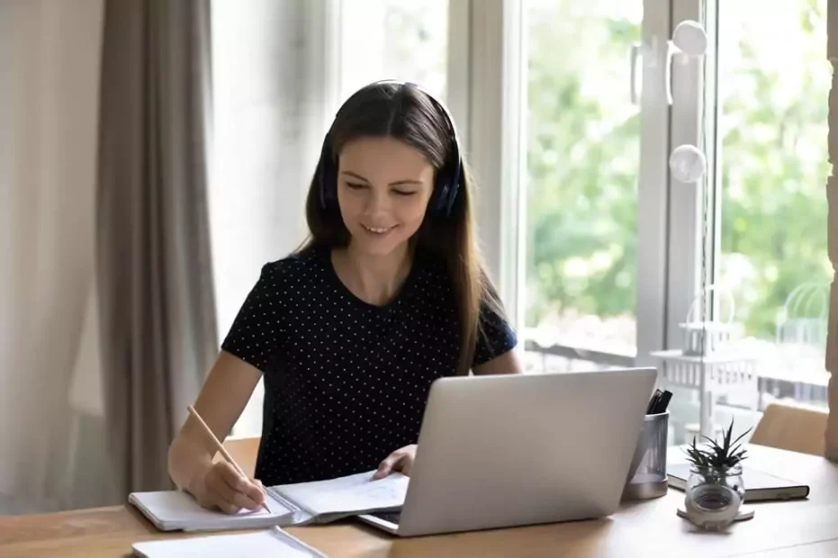 moça estudando com laptop e caderno