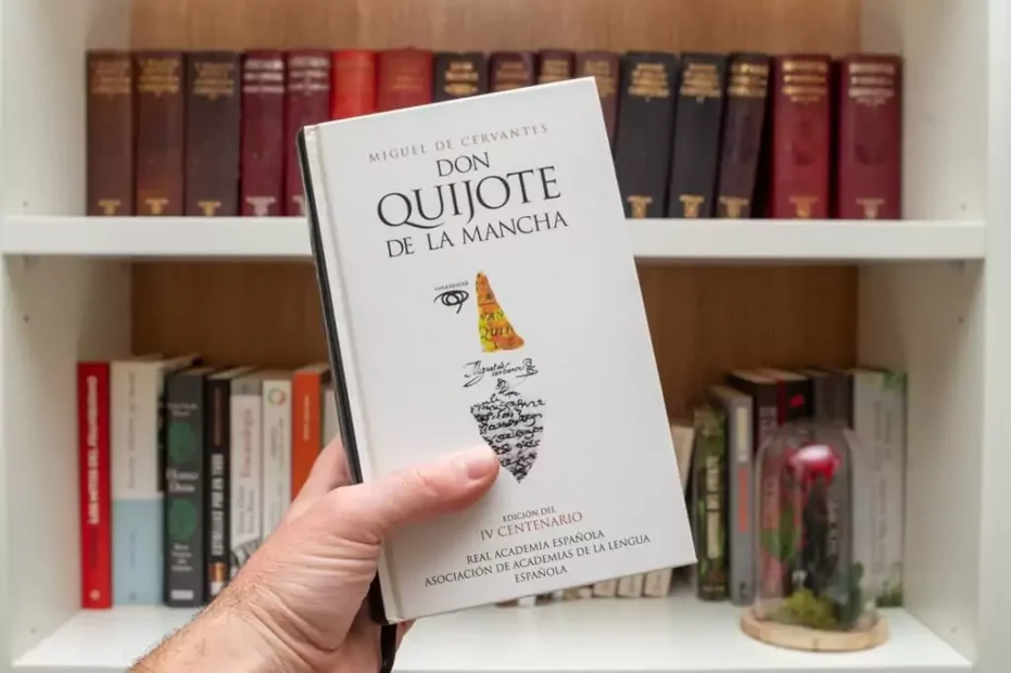 mão segurando livro Dom Quixote