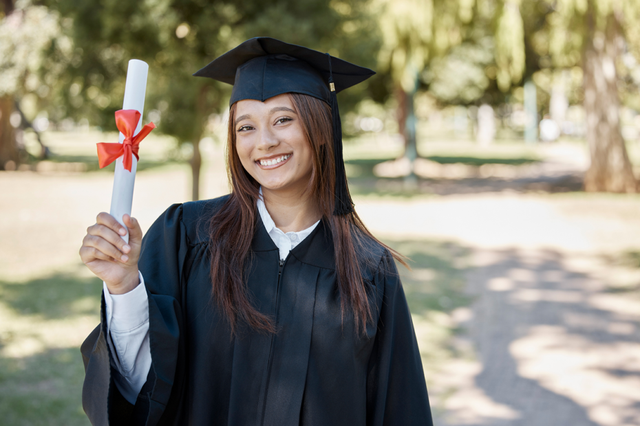 Mulher jovem vestida de de formanda e segurando seu diploma. Como entrar na faculdade.